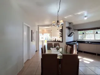 Ambiente interno com sala de jantar e cozinha em um apartamento.