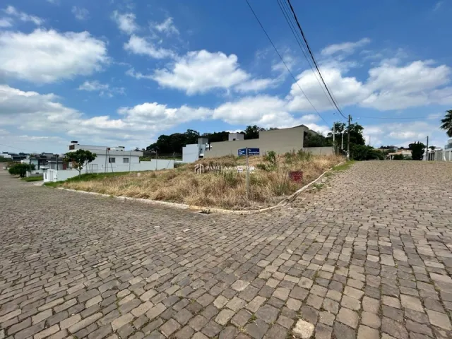 Vista externa de uma área pavimentada com grama seca.