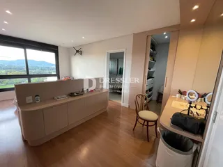 Ambiente interno de uma sala de estar com piso de madeira e grande janela.
