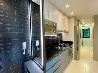 Vista da cozinha moderna com armários e bancadas escuras.