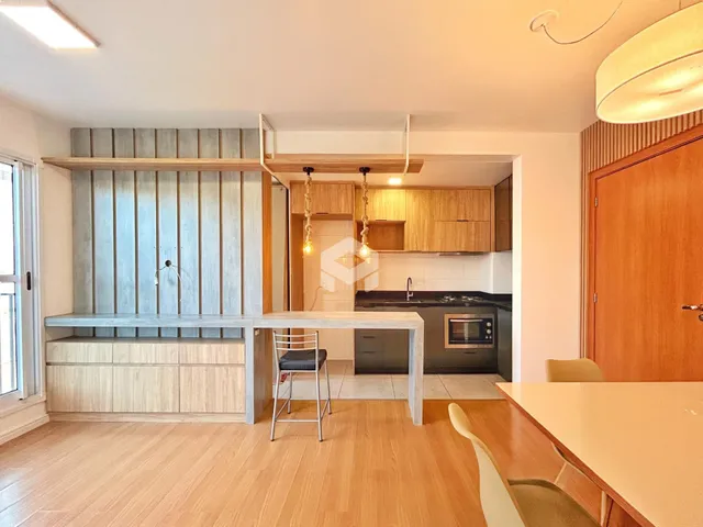 Interior de uma sala de estar com cozinha em um apartamento no Brasil.