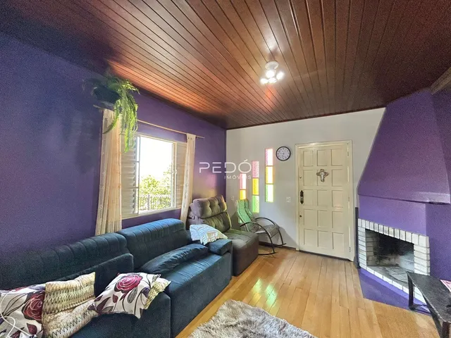 Sala de estar com piso de madeira e teto inclinado na Lajeado.