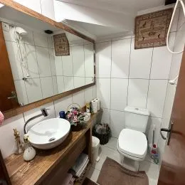 Foto de um banheiro com pia de cerâmica e espelho.