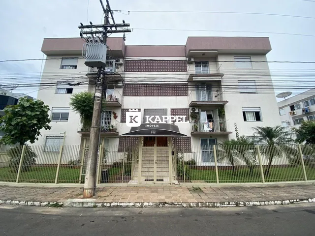 Fachada de um prédio residencial em Lajeado, Brasil, com cerca frontal e vegetação.