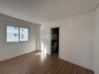 Sala de estar com piso de madeira clara e parede branca em um imóvel no Brasil.