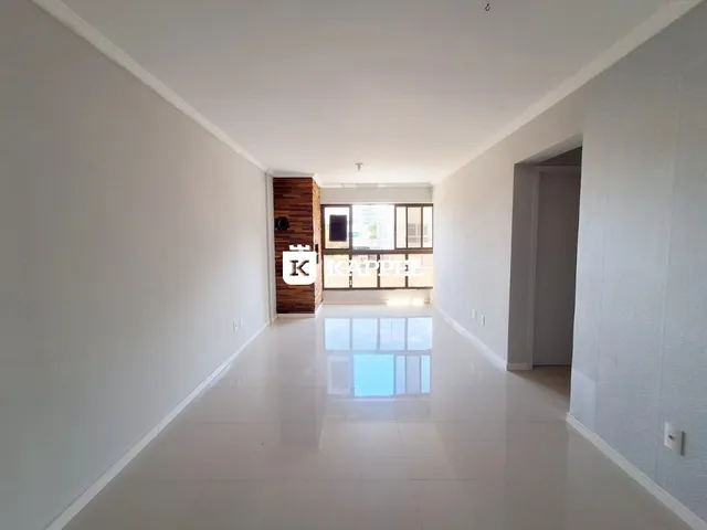 Hall de entrada longo com piso claro e parede de madeira no final do corredor.