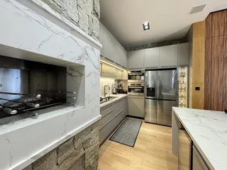 Vista da cozinha moderna com armários e eletrodomésticos em aço inoxidável.