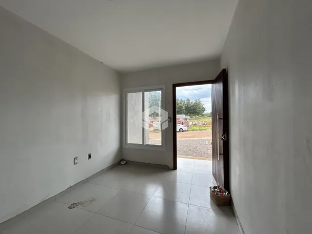 Interior de uma sala com paredes brancas e piso de cerâmica.