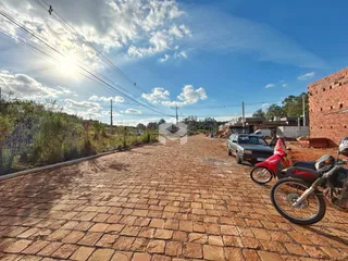 Vista da rua pavimentada em Lajeado, Brasil, com muro de tijolos ao lado.