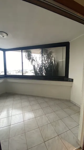 Vista de um ambiente interno com piso de cerâmica e grande janela.