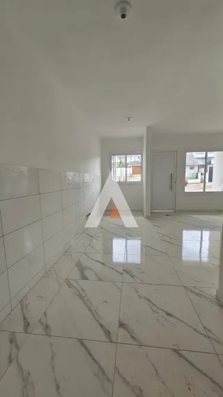 Interior de uma sala ampla com piso de mármore branco.
