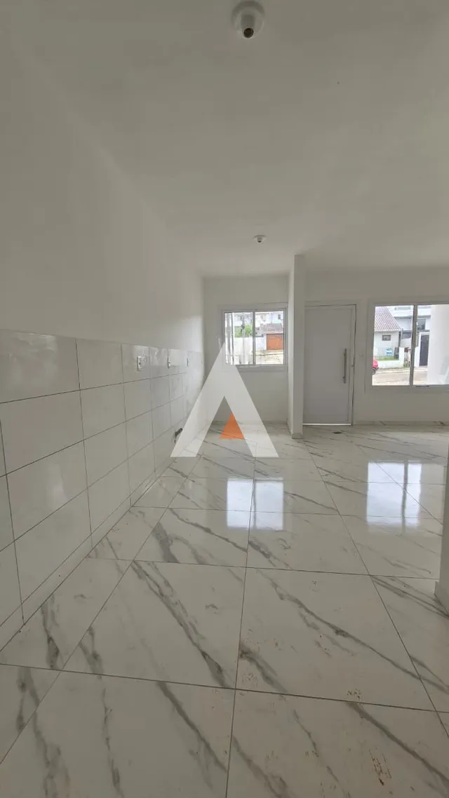 Interior de uma sala ampla com piso de mármore branco.