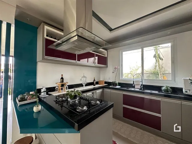Cozinha moderna com armários brancos e detalhes em vermelho.