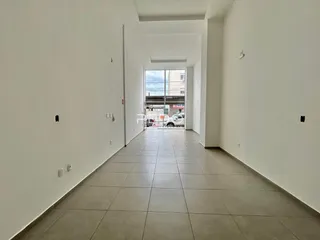 Corredor interno de uma residência com piso de cerâmica claro.