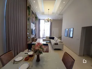 Sala de estar com grandes janelas e cortinas em um imóvel no Brasil.