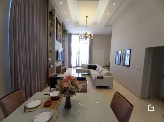 Sala de estar com grandes janelas e cortinas em um imóvel no Brasil.