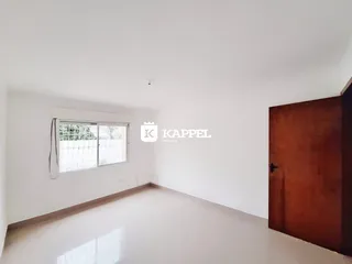 Foto de uma sala ampla e vazia com uma janela.