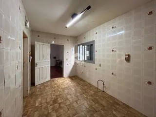 Corredor com paredes e piso revestidos de cerâmica.
