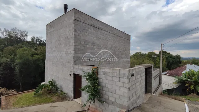 Fachada externa de uma construção em blocos cinzas em Lajeado.