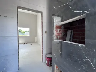 Uma vista de um corredor com paredes de concreto aparente.