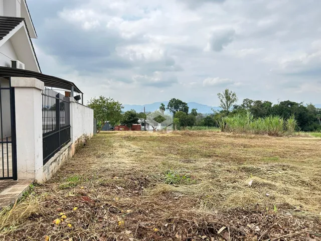 Fachada de uma residência com cerca e terreno gramado seco