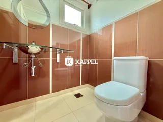 Foto de um banheiro com revestimento de azulejos marrons e vaso sanitário branco.