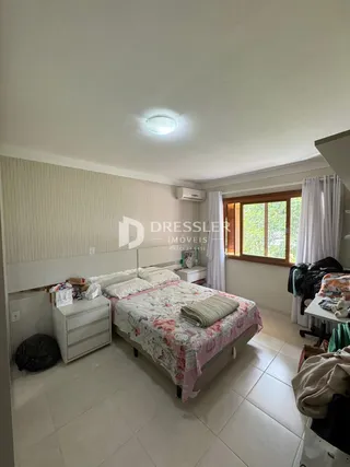 Quarto com cama e armário branco em um imóvel no Brasil.