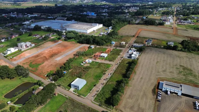 Vista aérea de um terreno rural com campos abertos e algumas estruturas.
