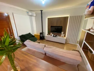 Sala de estar com sofá e televisão em um apartamento.