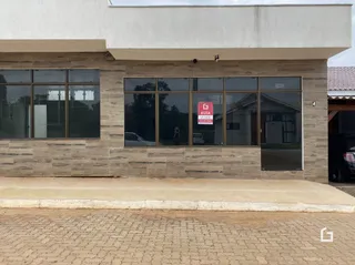 Fachada de uma residência com revestimento de pedra e grandes janelas.