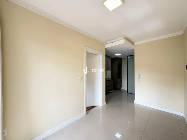 Hall de entrada com paredes claras e piso de cerâmica.