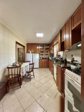 Uma sala de jantar com móveis de madeira e piso de cerâmica.