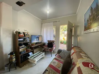 Sala de estar com sofá e televisão em um imóvel no Brasil.