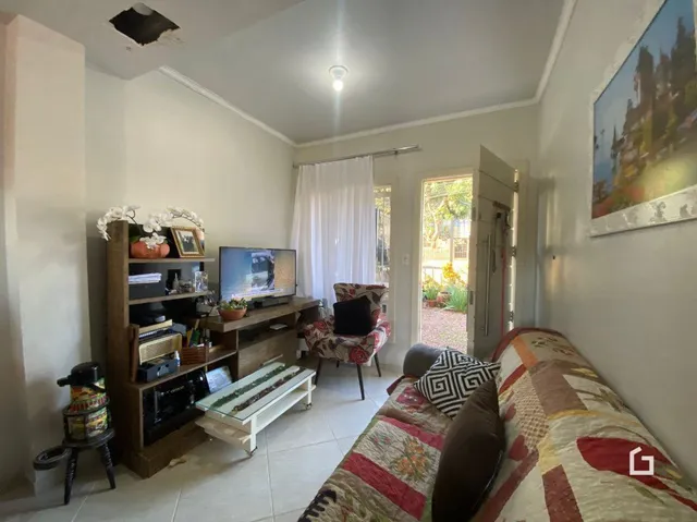 Sala de estar com sofá e televisão em um imóvel no Brasil.