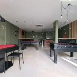 Foto de um ambiente interno com mesas longas e cadeiras em um espaço de jantar.