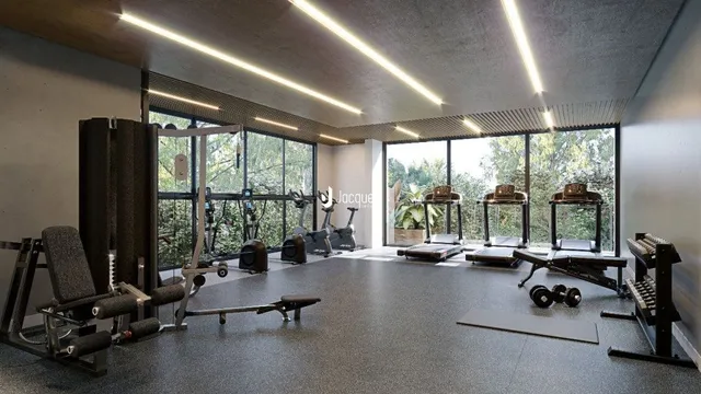 Foto de uma área de ginástica interna com equipamentos de treino.