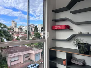 Interior com prateleiras escuras e uma grande janela com vista para a paisagem.