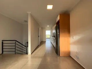 Corredor interno de uma residência com escadaria e armário alto.