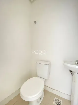 Foto de um ambiente interno com vaso sanitário branco.