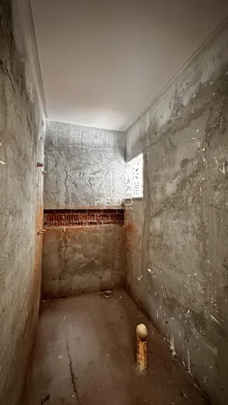Corredor interno com paredes de concreto aparente.