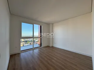 Sala de estar com vista para a paisagem urbana de Lajeado.