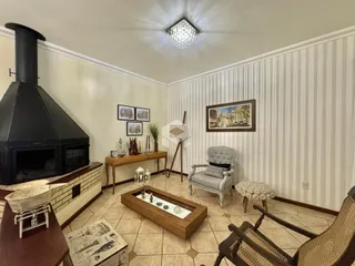 Sala de estar com lareira e decoração rústica em Lajeado.