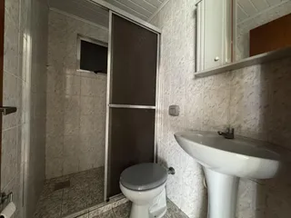 Foto de um banheiro com revestimento de cerâmica e box de vidro.