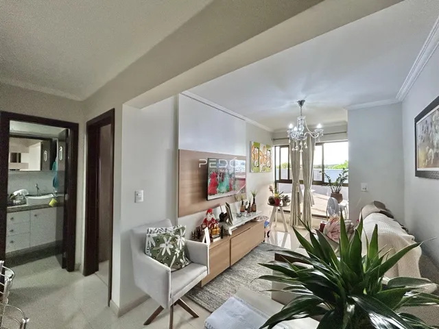 Sala de estar moderna com decoração neutra e móveis de madeira.
