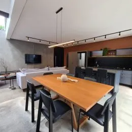 Foto de uma mesa de madeira com cadeiras em um ambiente interno.