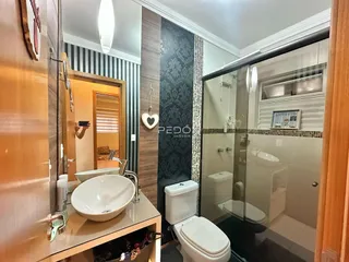 Foto de um banheiro com box de vidro e pia.