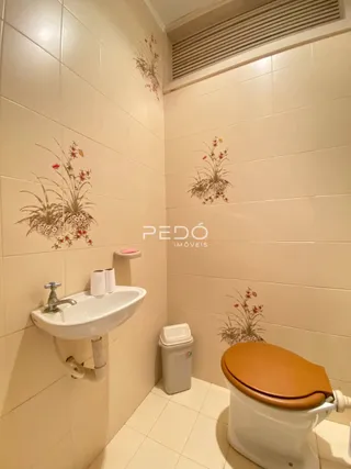 Foto do interior de um banheiro com revestimento cerâmico nas paredes.