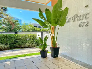 Vista externa da fachada de um imóvel com plantas tropicais e piso de cerâmica.