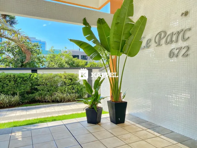 Vista externa da fachada de um imóvel com plantas tropicais e piso de cerâmica.