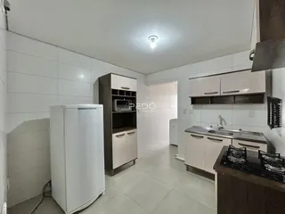 Foto de uma cozinha com armários brancos e piso claro.